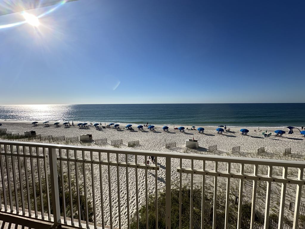 View from balcony of beach with blue umbrellas