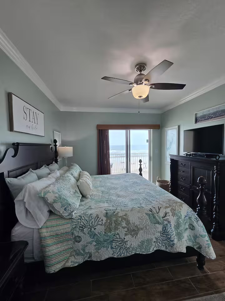 Master bedroom with sliding doors to balcony and ocean views